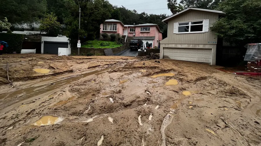 Mud and storm runoff across a hillside street after a heavy winter rain in Southern California
